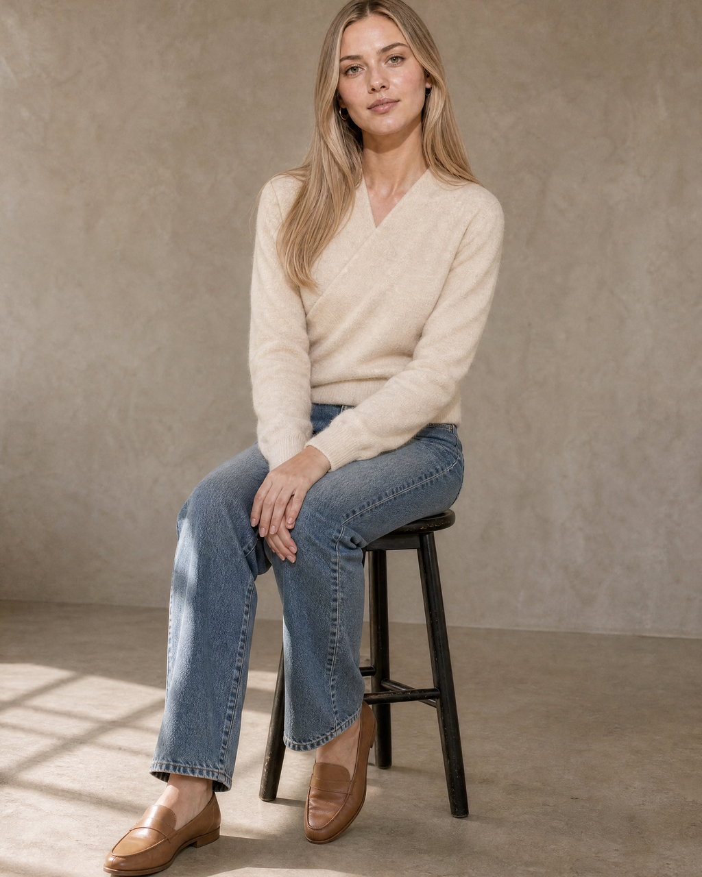 Women's Wrap V-Neck Knit Sweater for Everyday Layering in Vanilla beige, stool, side sit with hands on knee, worn by model